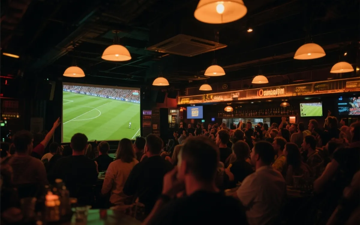 夜晚酒吧里多人观看足球比赛的大屏,氛围热烈